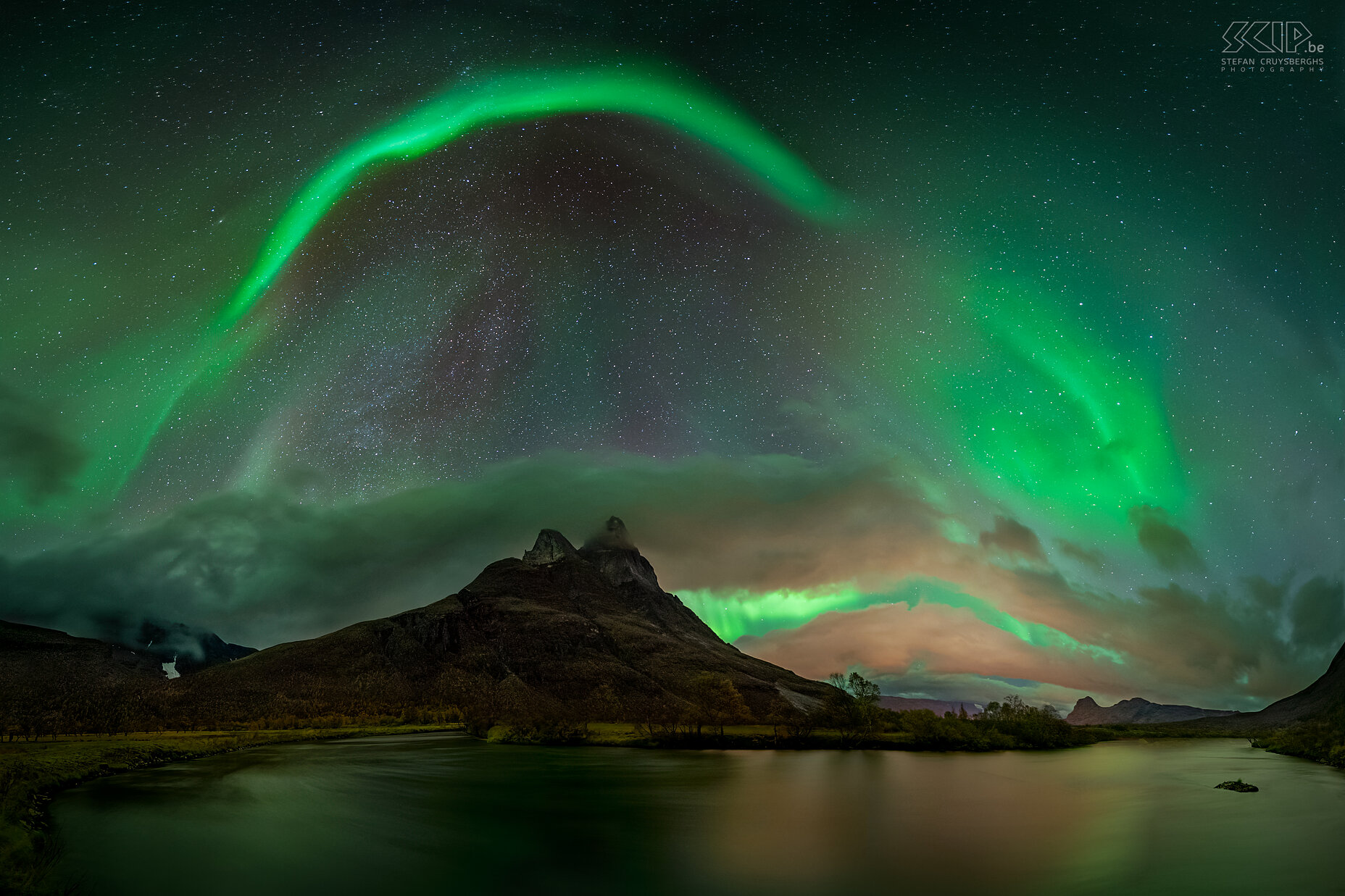 Oteren - Otertinden - Noorderlicht Een tweede nacht gingen we fotograferen nabij de de Signaldalelva rivier met zicht op de top van de beroemde berg Otertinden op een uurtje rijden van Tromso. Er waren wat meer wolken maar het noorderlicht was prachtig en met momenten zeer intens. Dit is een panoramabeeld met een mooie noorderlichtboog boven de twee scherpe pieken van de Otertinden (1356m)<br />
 Stefan Cruysberghs